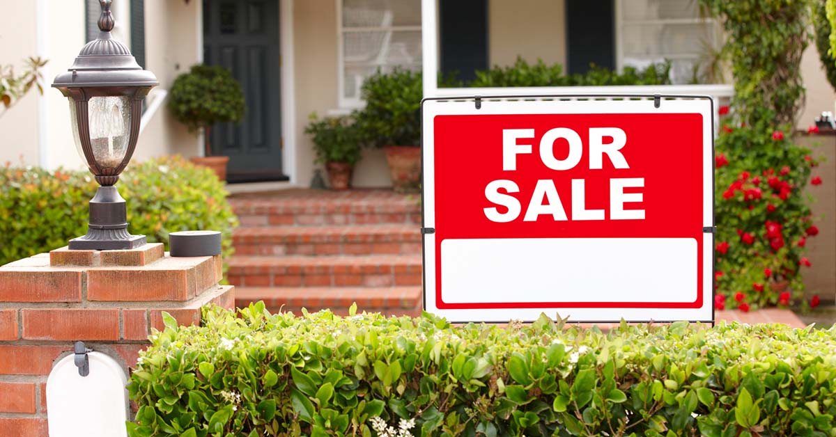 Image-of-a-for-sale-sign-in-front-of-a-beautiful-home