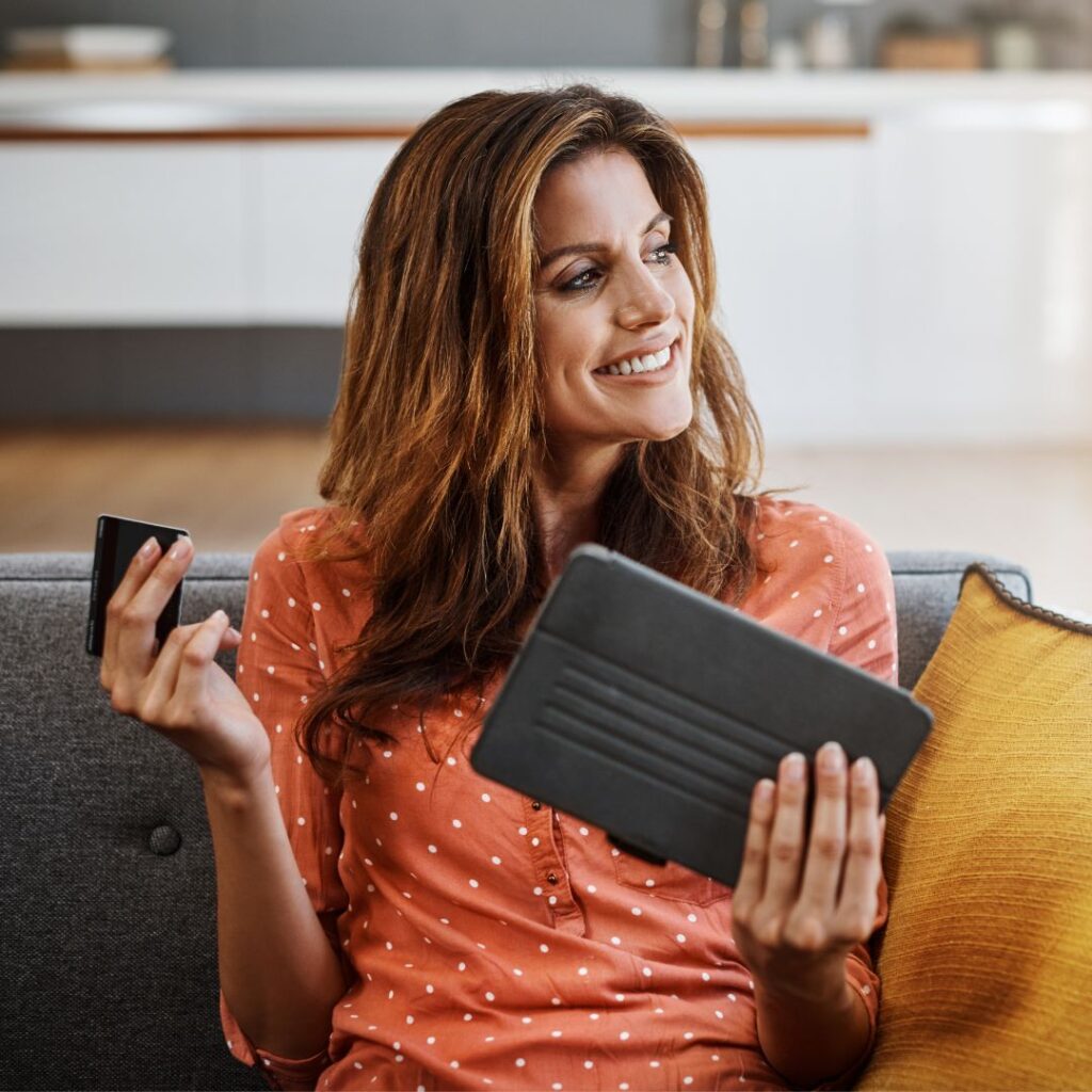 person holding credit card and tablet