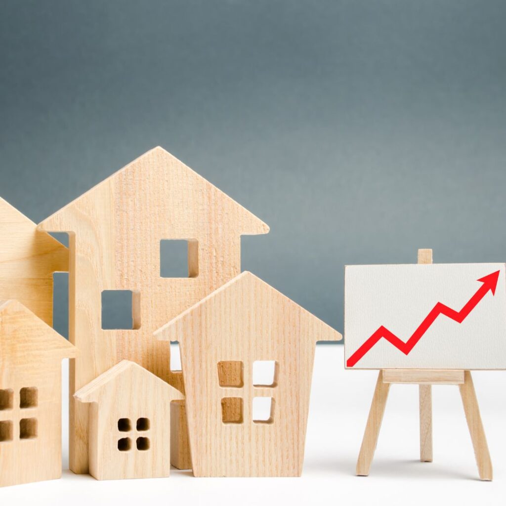 wooden houses next to graph with arrow increasing
