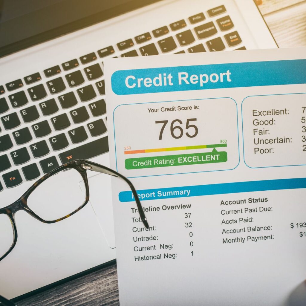 good credit score on laptop next to glasses