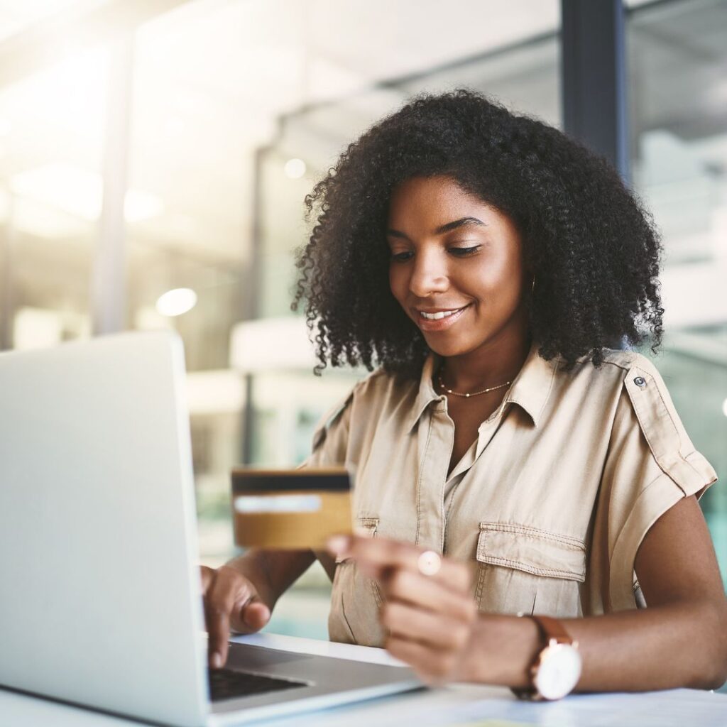 girl at computer with credit card smiling